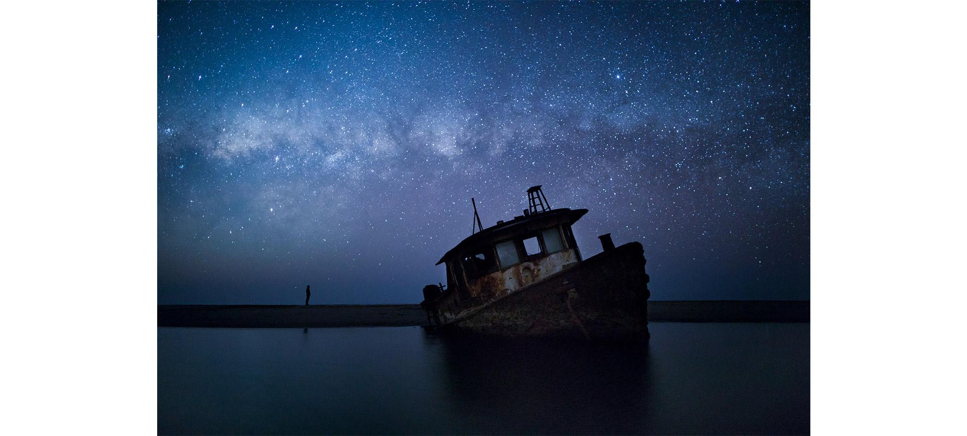 Traînées d’étoiles de la Voie lactée avec météores, étoiles filantes et silhouettes de campagne.