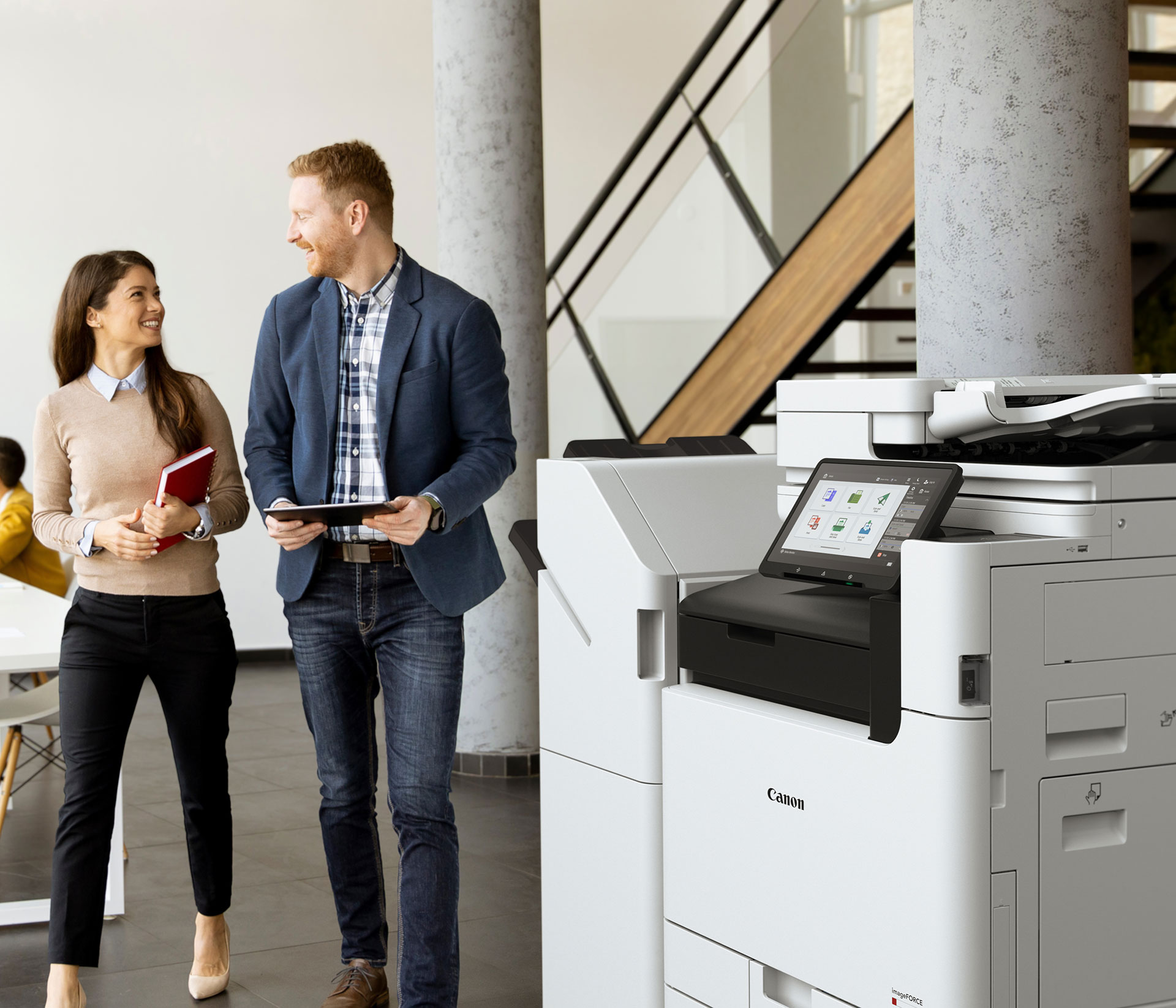 Canon imagerunner in an office with two office workers walking in the background