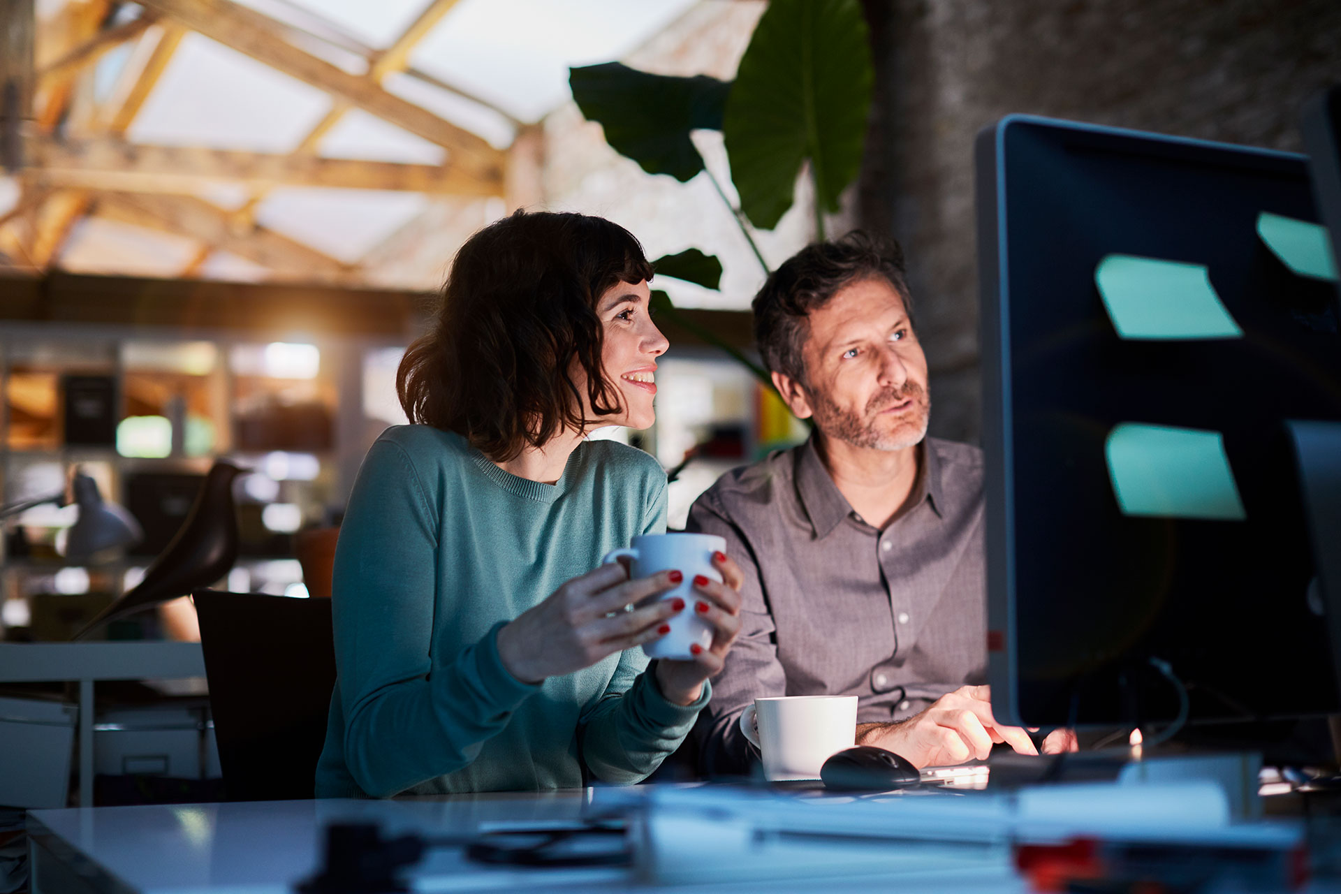 two office workers looking at a computer screen together