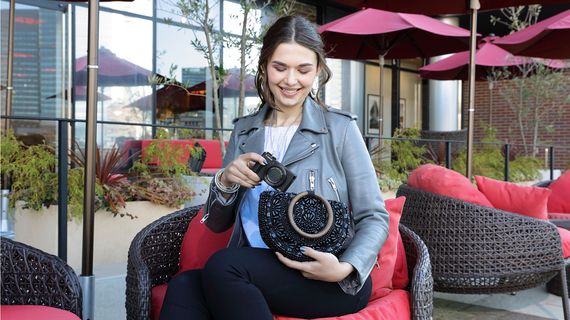 woman pulling a G7 X Mark III from her purse